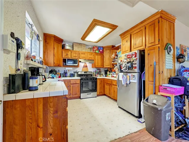 a living room with stainless steel appliances kitchen island granite countertop furniture and a refrigerator
