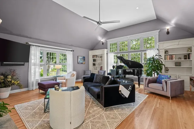 a living room with furniture a flat screen tv and a large window