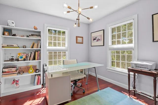a view of a workspace with furniture and a window