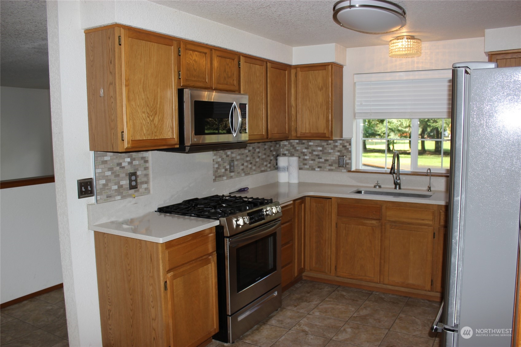 9441 Gastaeson Lane Southwest Rochester, WA 98579 - Photo 15 of 40 a kitchen with stainless steel appliances granite countertop a stove a sink and a microwave