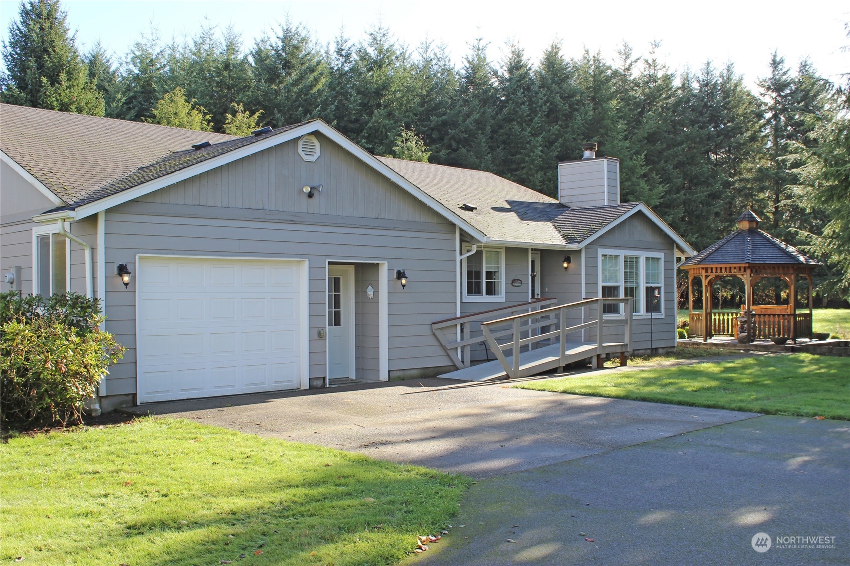 9441 Gastaeson Lane Southwest Rochester, WA 98579 - Photo 4 of 40 a view of a house with garden and trees in the background