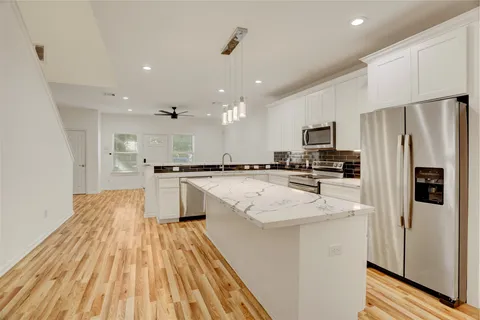 a backyard of a house with plants and wooden fence