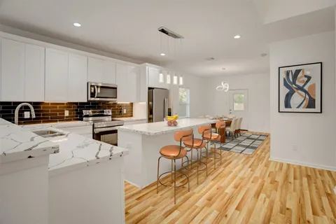 a kitchen with stainless steel appliances a stove a sink and a white cabinets