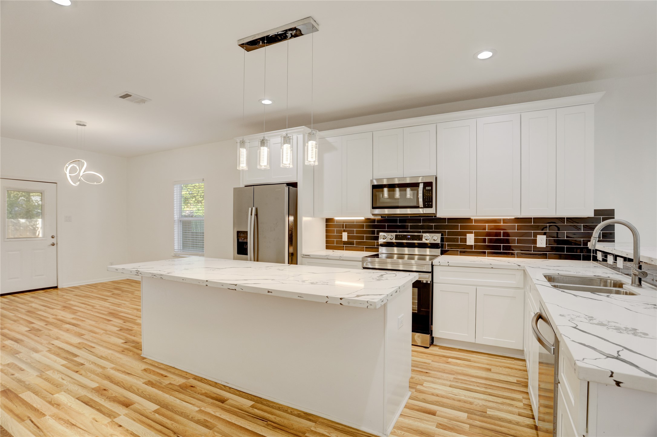 5317 Chennault Road, Unit A / B Houston, TX 77033 - Photo 8 of 27 a kitchen with stainless steel appliances granite countertop a sink dishwasher stove top oven and refrigerator