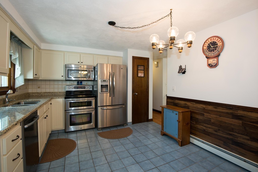 132 Spring Street Stoneham, MA 02180 - Photo 14 of 30 a kitchen with granite countertop a refrigerator and a stove top oven