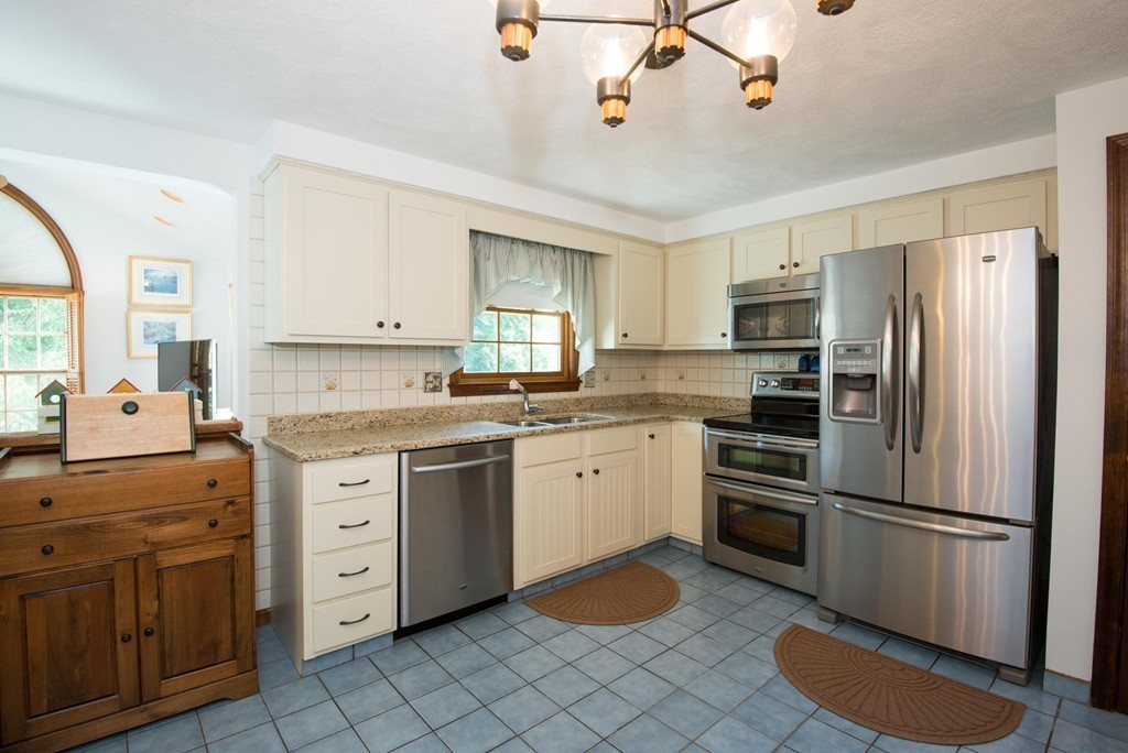 132 Spring Street Stoneham, MA 02180 - Photo 15 of 30 a kitchen with granite countertop cabinets stainless steel appliances and a window
