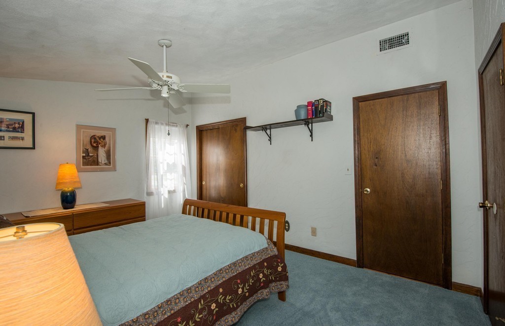 132 Spring Street Stoneham, MA 02180 - Photo 21 of 30 a bedroom with a bed and a chandelier