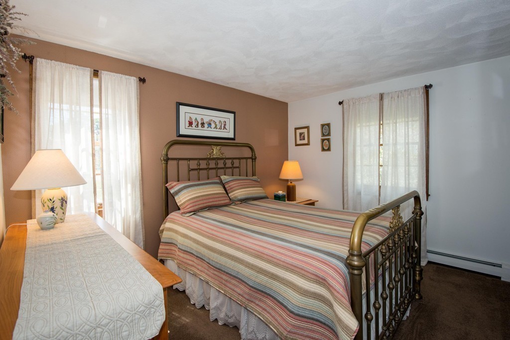 132 Spring Street Stoneham, MA 02180 - Photo 23 of 30 a bedroom with a bed and a lamp
