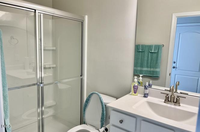 1807 Wrenn Road Durham, NC 27703 - Photo 23 of 43 a bathroom with a shower sink vanity mirror and toilet
