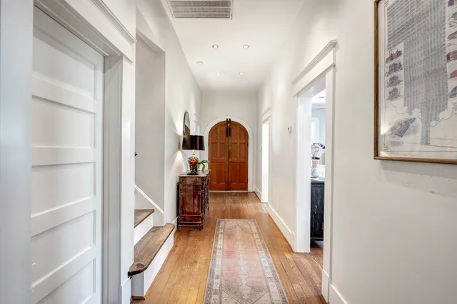 a view of a hallway with wooden floor and furniture