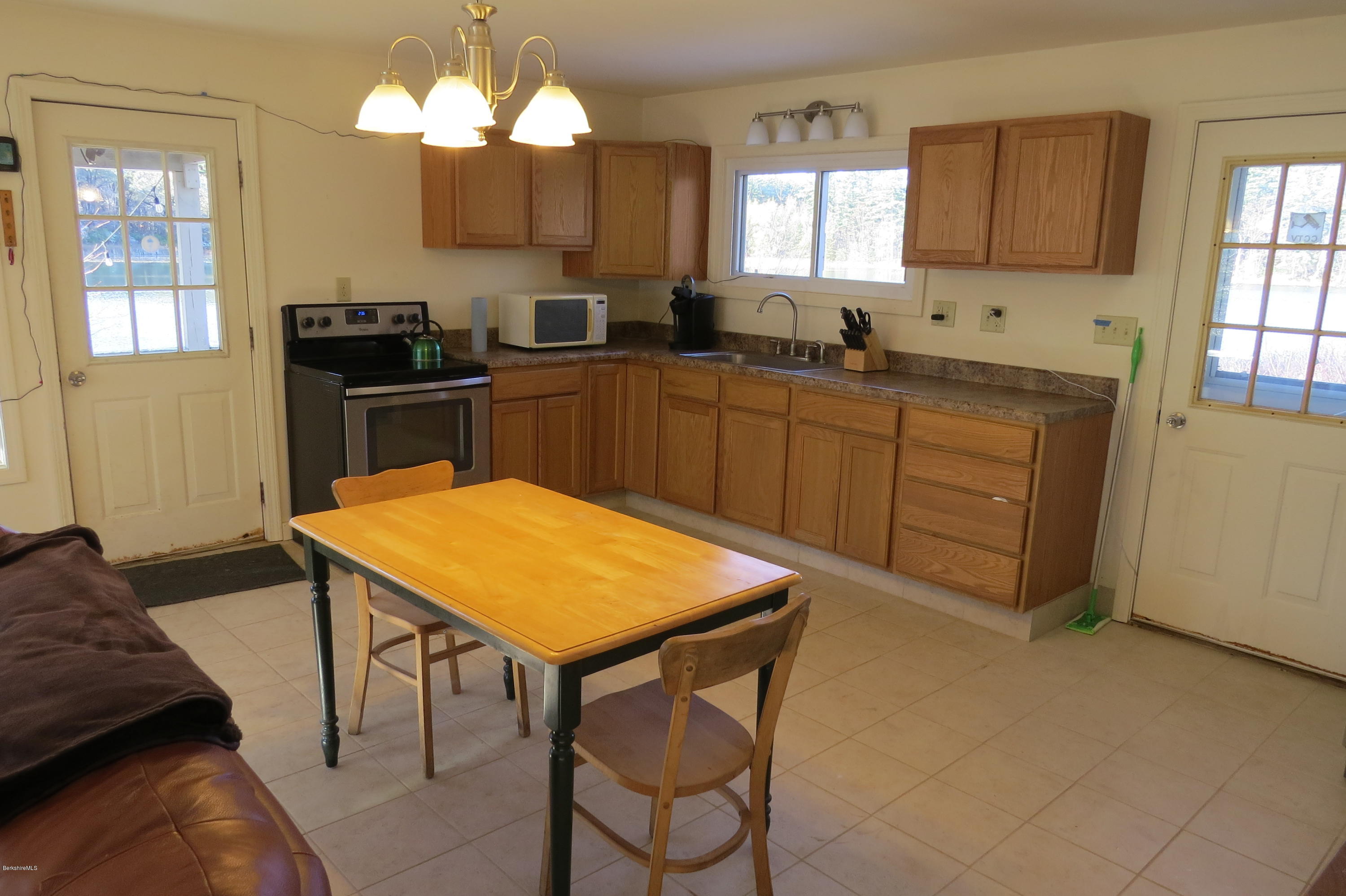 1601 Barber Pond Road Pownal, VT 05261 - Photo 9 of 34 a kitchen with a table chairs sink and cabinets