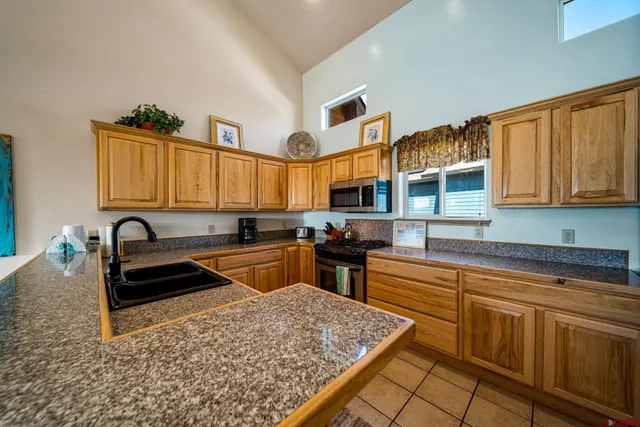 a kitchen with stainless steel appliances granite countertop sink stove and cabinets