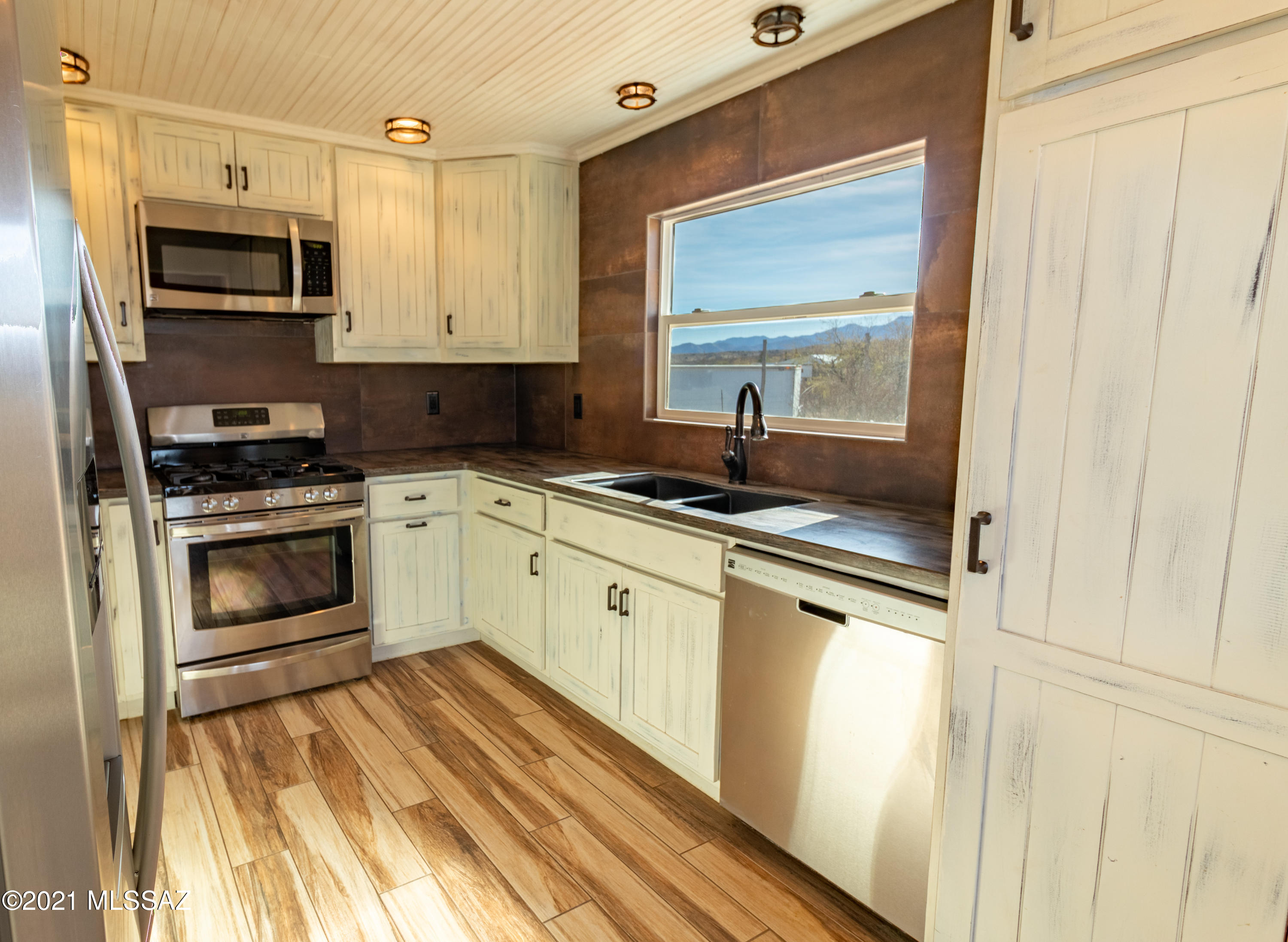 82063 East Goldbug Road Oracle, AZ 85623 - Photo 5 of 25 a kitchen with stainless steel appliances a stove a sink and a microwave