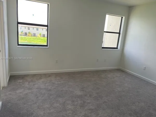 an empty room with windows and entrance