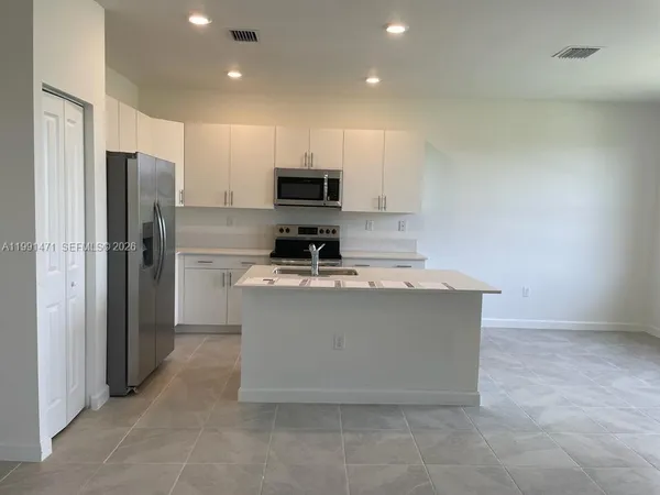 a kitchen with cabinets and stainless steel appliances