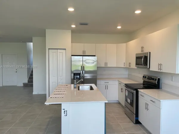 a kitchen with a sink a stove and cabinets