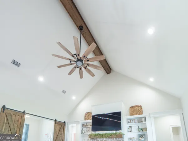 a kitchen with a refrigerator a sink dishwasher a stove and white cabinets with wooden floor
