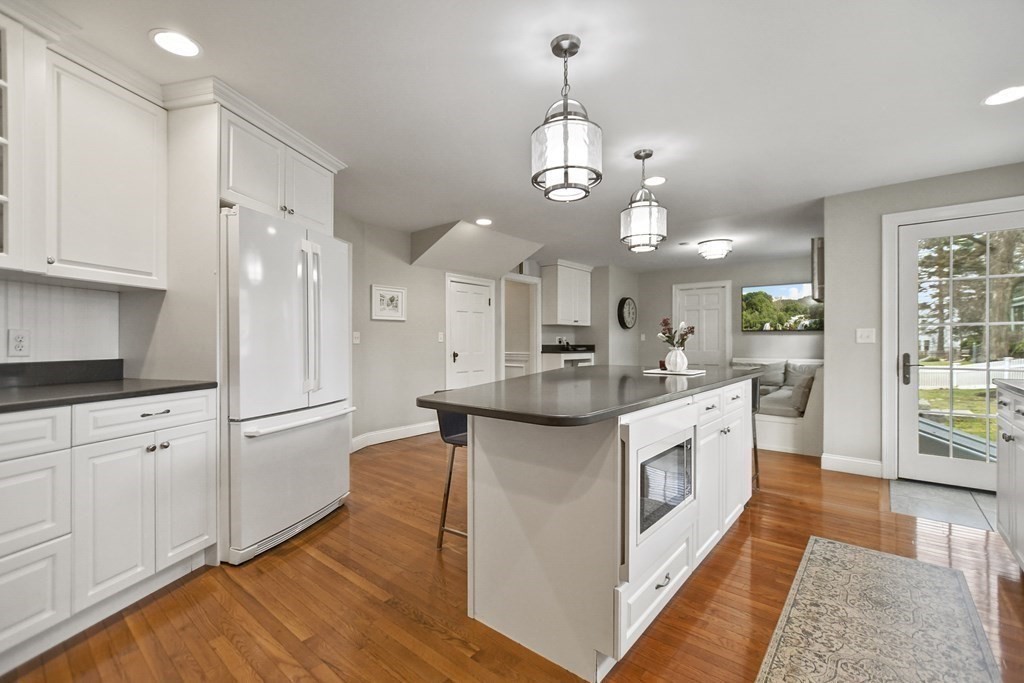 348 Webster Street Needham, MA 02494 - Photo 14 of 42 a large kitchen with stainless steel appliances kitchen island granite countertop a stove a sink a refrigerator and white cabinets with wooden floor