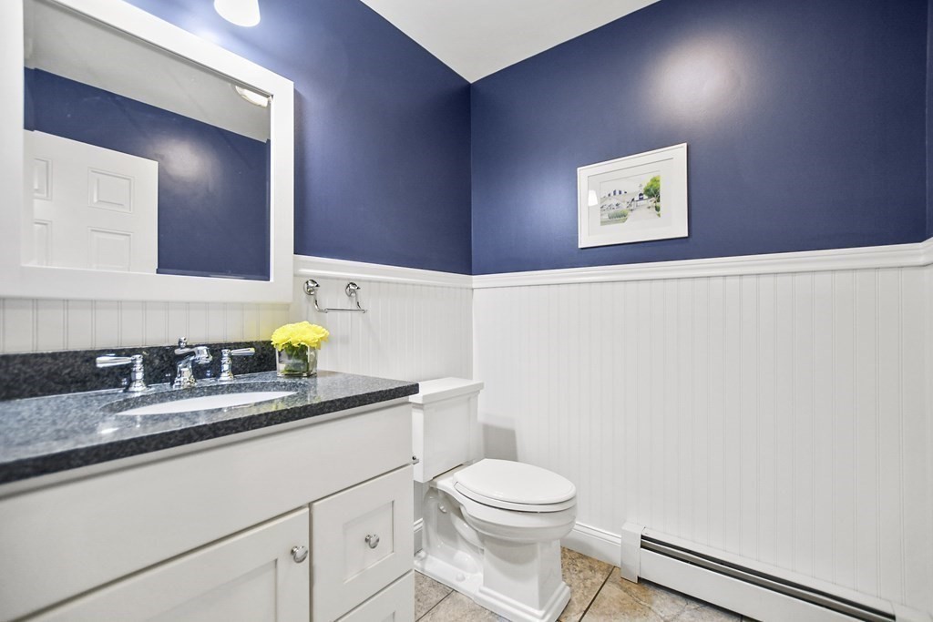 348 Webster Street Needham, MA 02494 - Photo 20 of 42 a bathroom with a granite countertop sink a toilet and mirror