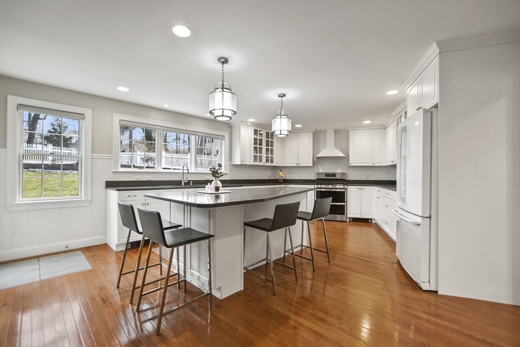 348 Webster Street Needham, MA 02494 - Photo 10 of 42 a kitchen with stainless steel appliances granite countertop a stove top oven a sink a refrigerator and white cabinets with wooden floor