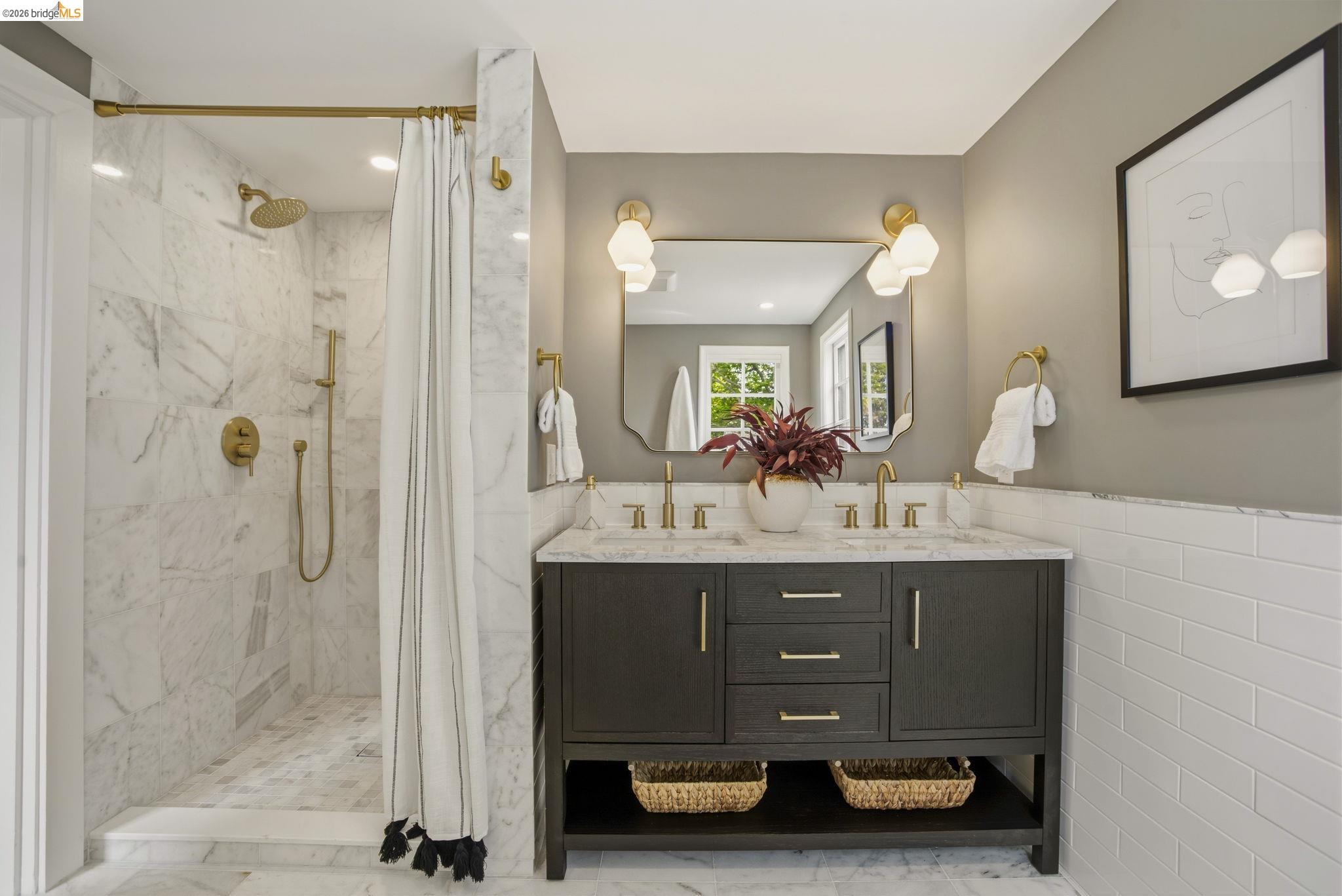 1087 Hubert Road Oakland, CA 94610 - Photo 23 of 67 Bathroom featuring a dual-sink vanity with a stone countertop, brass fixtures, and a shower enclosure with full-height tile surround and an integrated showerhead