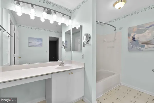 a bathroom with a tub a sink and mirrors