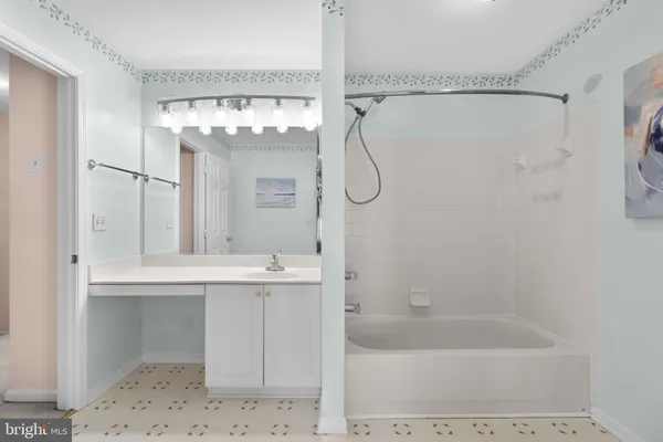 a bathroom with a bath tub sink mirror and a shower