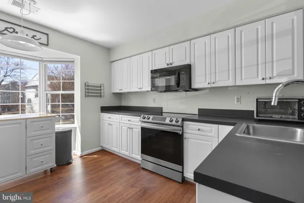 a kitchen with granite countertop a stove a sink and a microwave