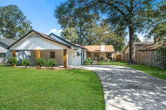 a front view of a house with a yard and trees