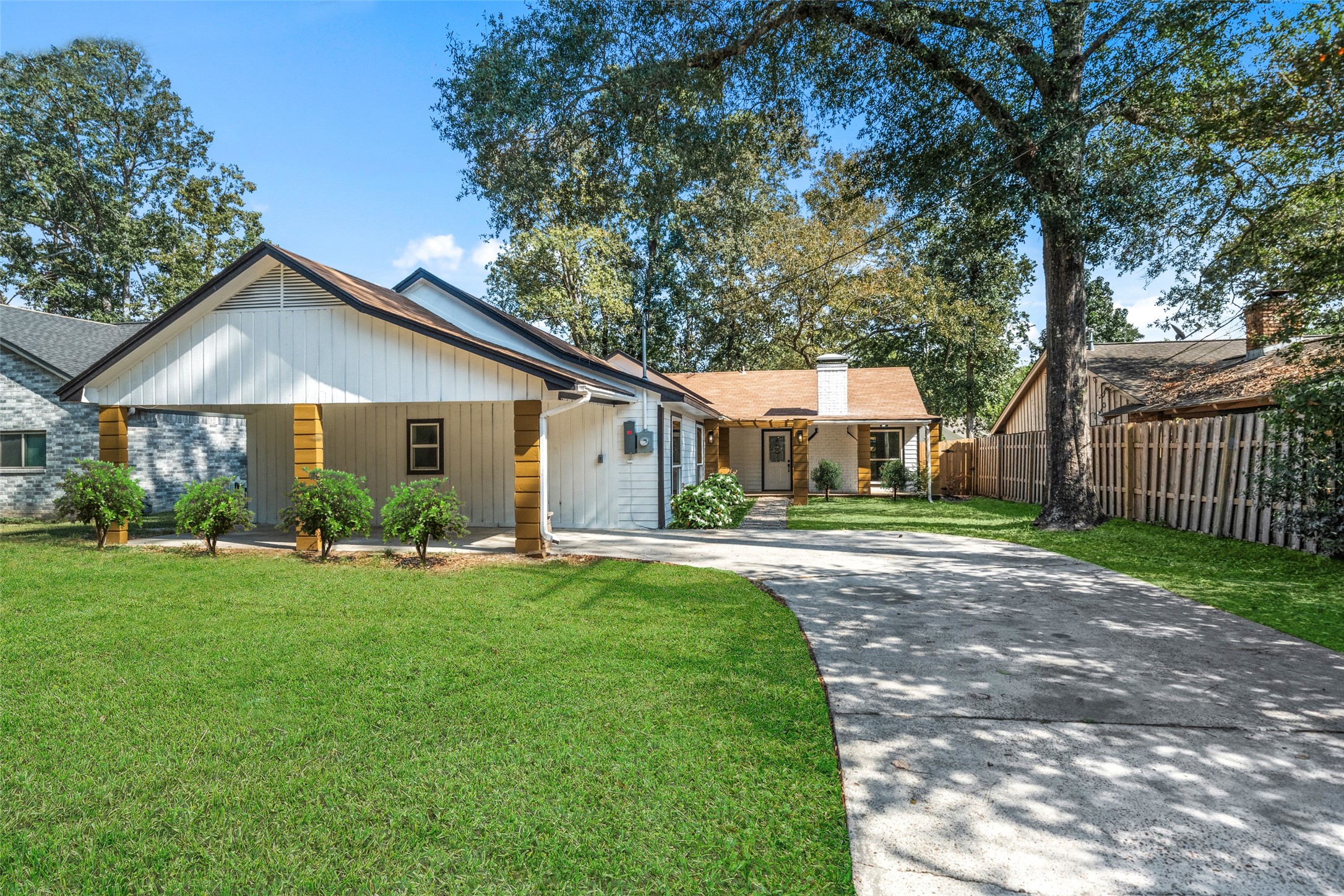 a front view of a house with a yard and trees