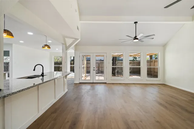a large kitchen with stainless steel appliances granite countertop a lot of counter space and wooden floors
