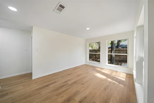 a view of empty room with a fireplace and wooden floor