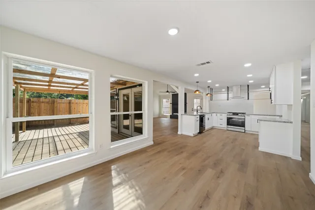 a large kitchen with stainless steel appliances granite countertop a lot of counter space and wooden floor