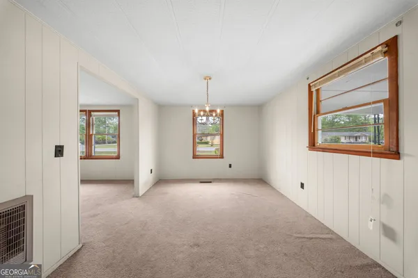 an empty room with windows and cabinet