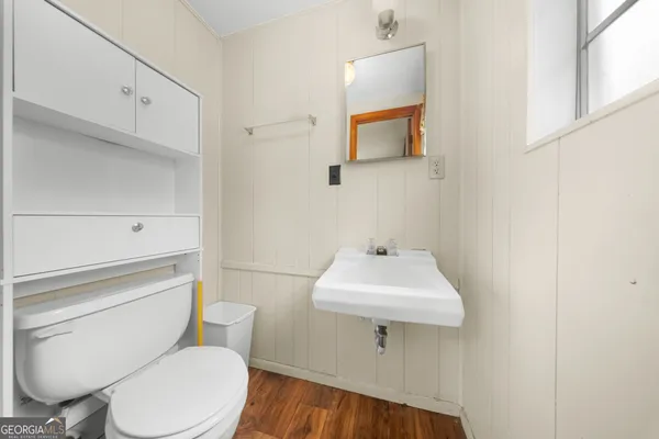 a bathroom with a toilet a sink and mirror