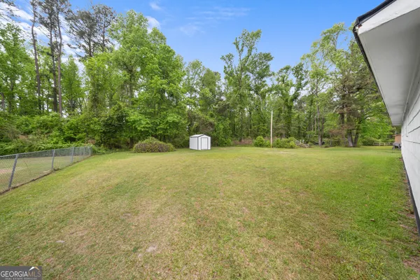 a view of a field with trees in background