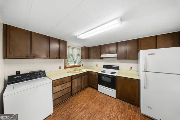 a kitchen with cabinets a sink and white stainless steel appliances