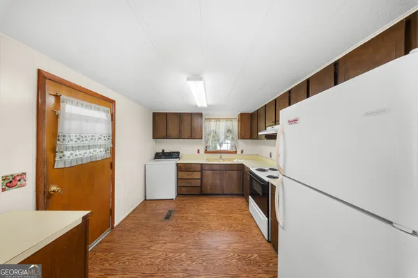 a kitchen with a refrigerator a stove top oven and a sink