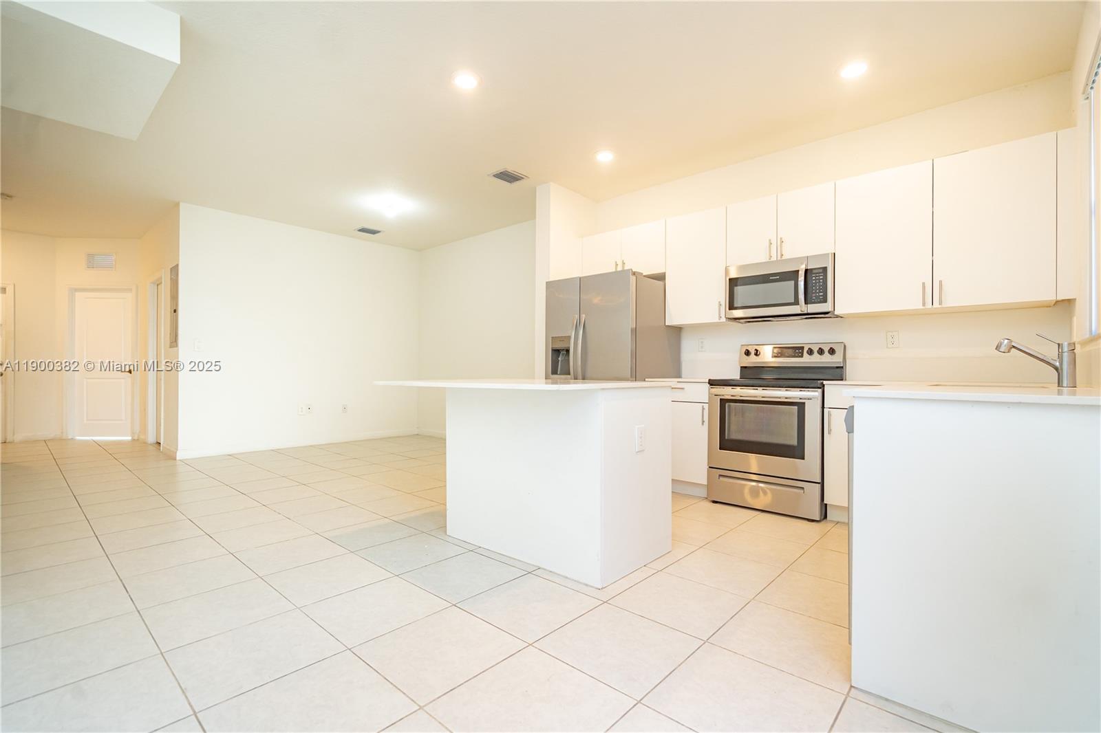13237 Southwest 286th Street, Unit 13237 Homestead, FL 33033 - Photo 11 of 48 a kitchen with stainless steel appliances a refrigerator sink and microwave