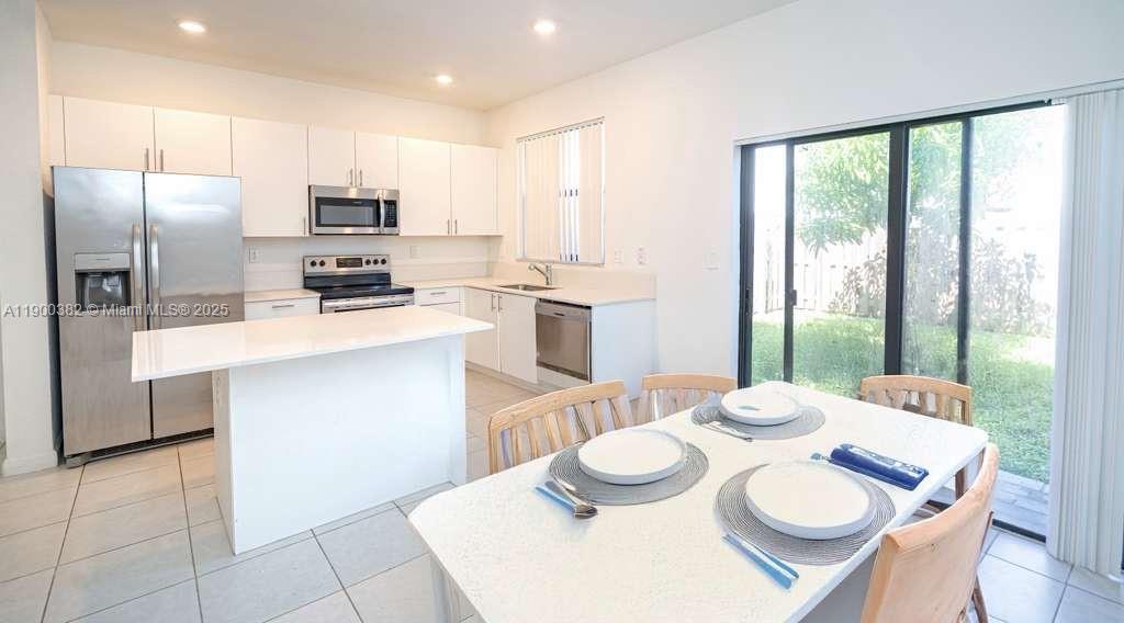 13237 Southwest 286th Street, Unit 13237 Homestead, FL 33033 - Photo 3 of 48 a kitchen with stainless steel appliances a dining table and chairs