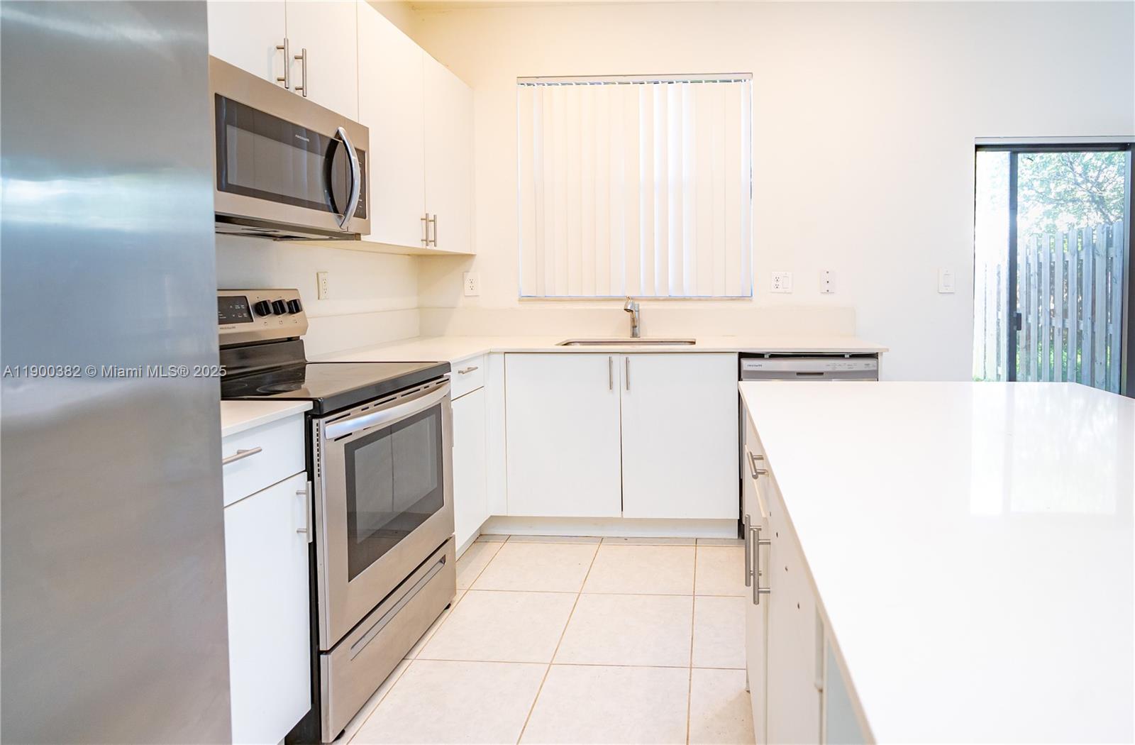 13237 Southwest 286th Street, Unit 13237 Homestead, FL 33033 - Photo 7 of 48 a kitchen with stainless steel appliances a refrigerator and a stove top oven