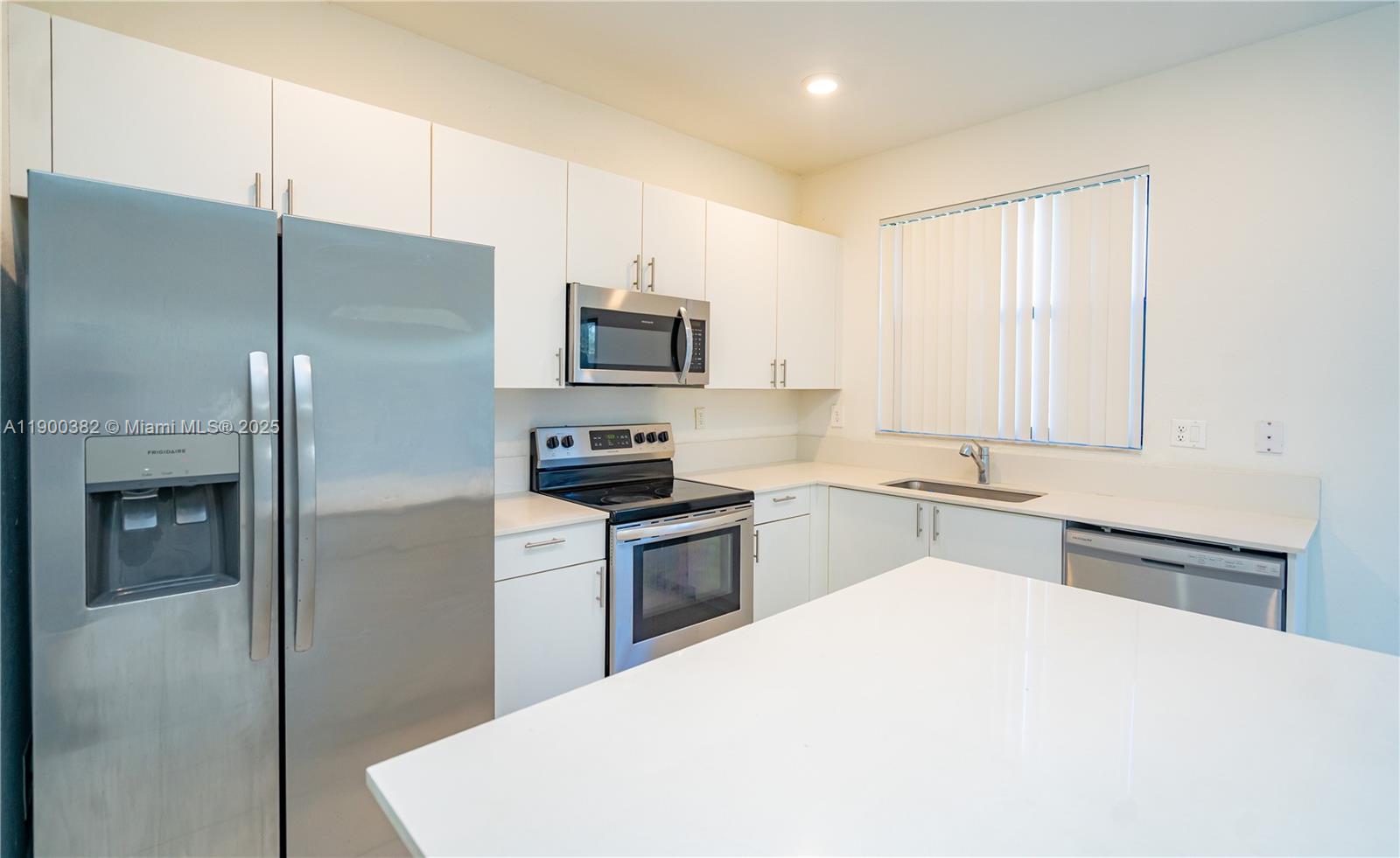13237 Southwest 286th Street, Unit 13237 Homestead, FL 33033 - Photo 10 of 48 a kitchen with stainless steel appliances a refrigerator sink and stove