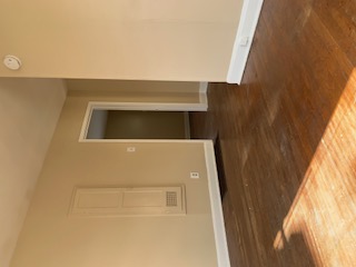 1105 Bentwood Road, Unit B Austin, TX 78722 - Photo 2 of 9 Spare room featuring baseboards and dark wood-type flooring