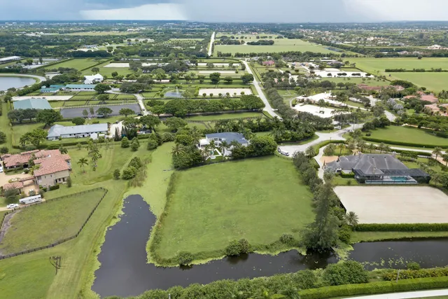 an aerial view of a residential houses with outdoor space and river