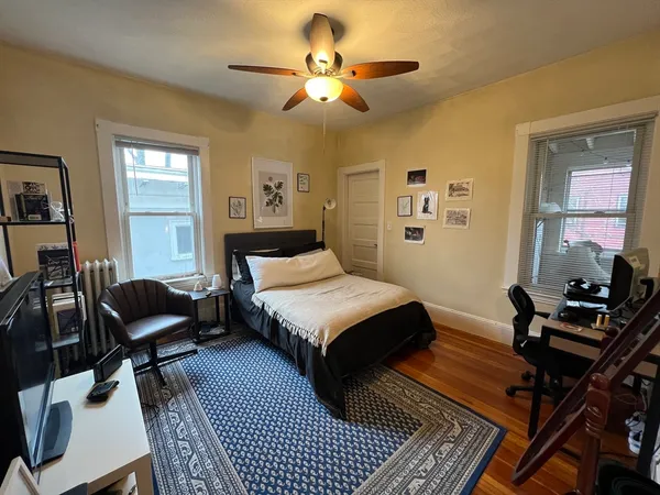 a bedroom with a bed and wooden floor
