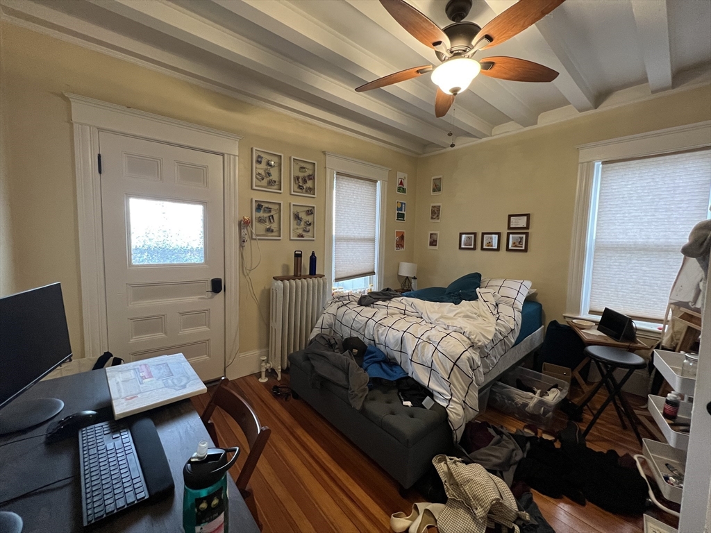 121 Liberty Road, Unit 3 Somerville, MA 02144 - Photo 6 of 24 a bedroom with a bed and a chandelier