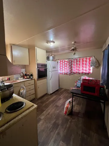 a kitchen with a sink dishwasher a stove and a refrigerator with wooden floor