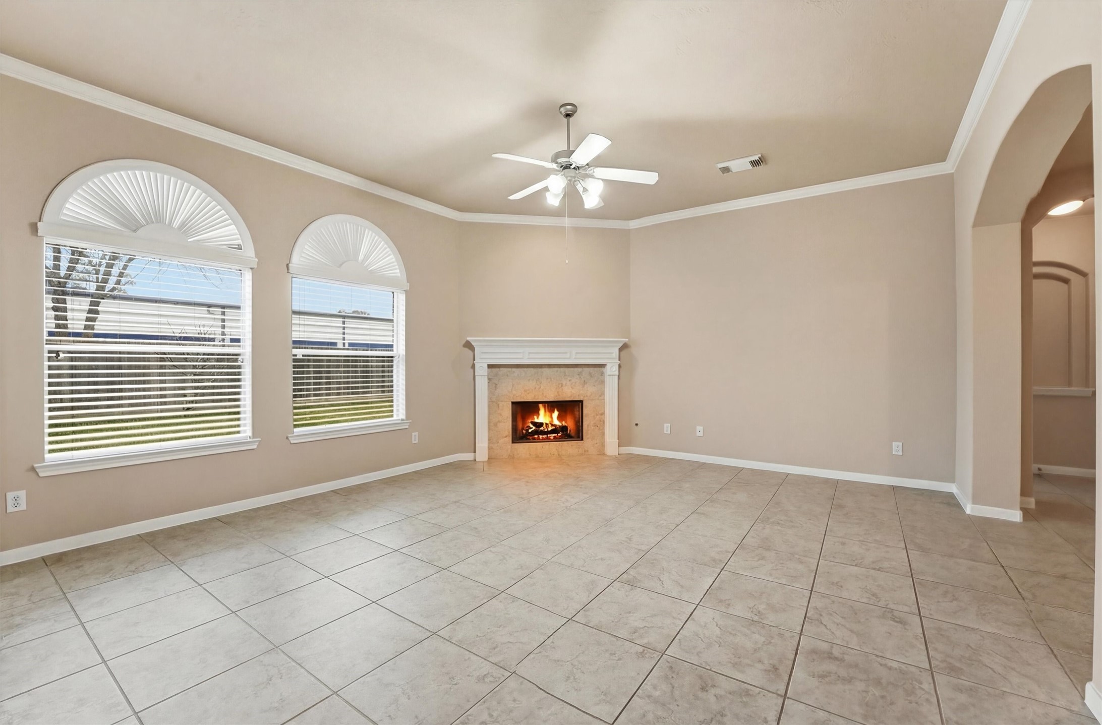 17415 Memorial Mills Drive Spring, TX 77379 - Photo 15 of 39 The main living room features tile flooring, crown molding, arched openings, and a gas fireplace with classic mantel.