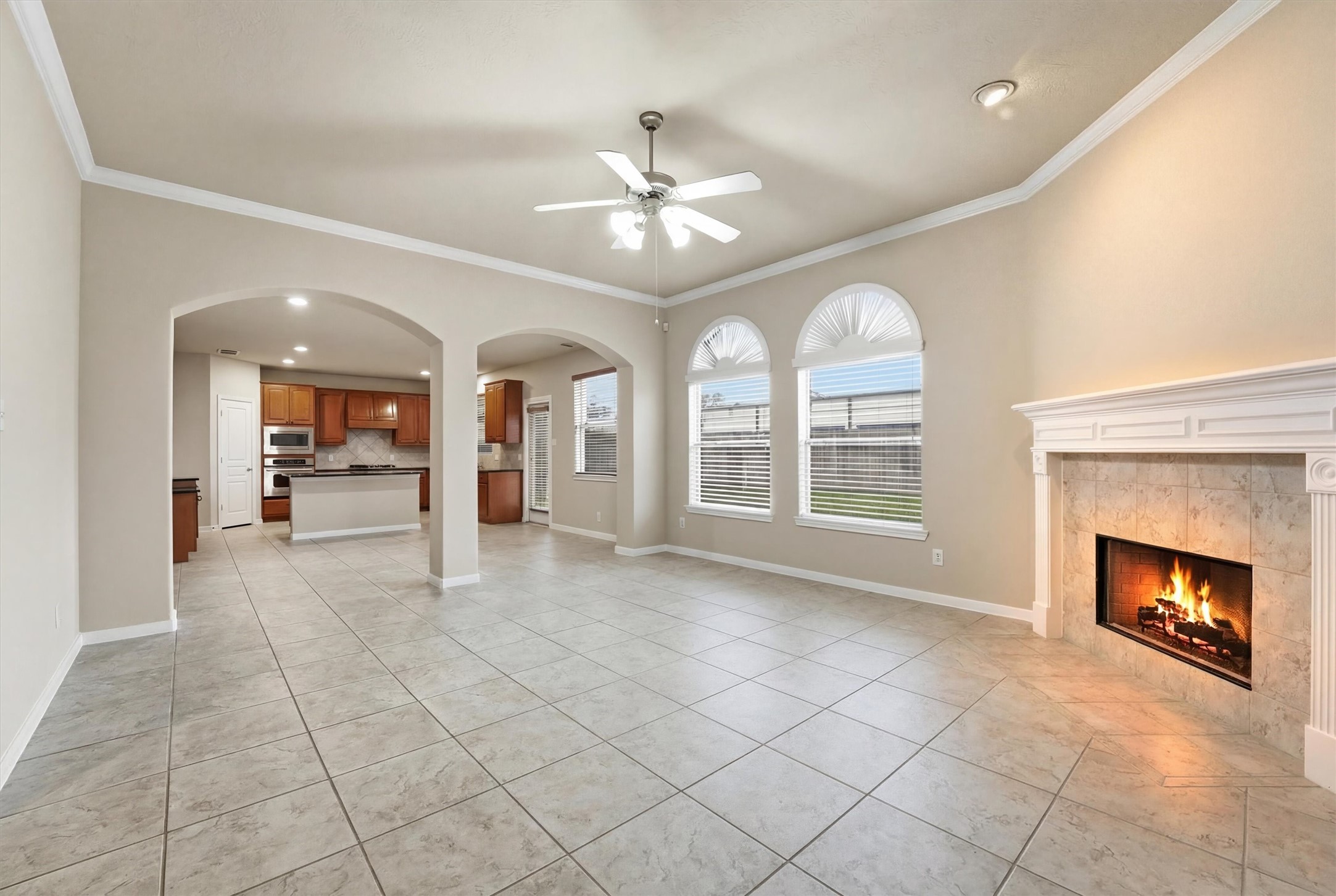 17415 Memorial Mills Drive Spring, TX 77379 - Photo 16 of 39 Same living area (aka family room) shown without virtual staging, highlighting arched openings to the casual dining area and kitchen beyond.