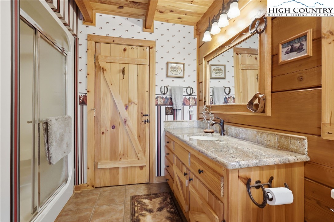 130 Hawkbill Road Ferguson, NC 28624 - Photo 14 of 50 a bathroom with a granite countertop shower a sink and a mirror